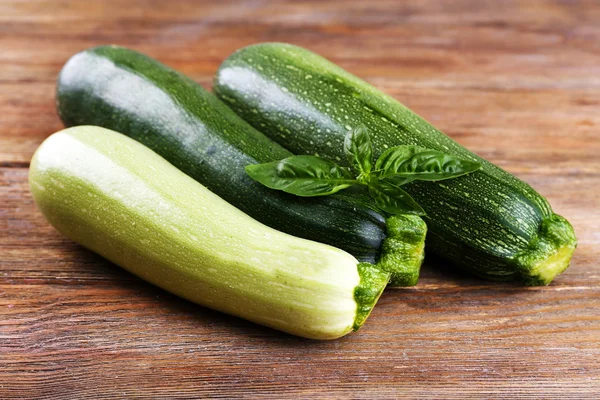 Fresh zucchini with squash and basil on wooden background — Stock Photo, Image