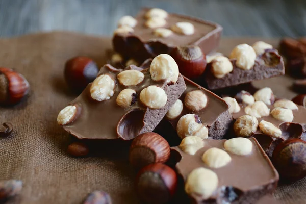 Chocolate with nuts on burlap cloth, closeup — Zdjęcie stockowe