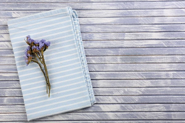 Beautiful dry flowers on napkin on wooden background — Stock Photo, Image