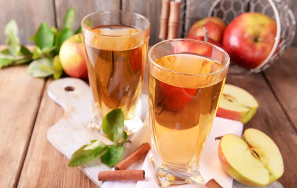 Vasos de jugo de manzana en la mesa de madera, primer plano — Foto de Stock