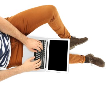 Beyaz izole dizüstü bilgisayar ile oturan genç adam