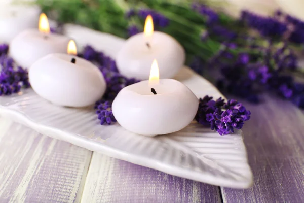 Kerzen mit Lavendelblüten auf dem Tisch in Großaufnahme — Stockfoto