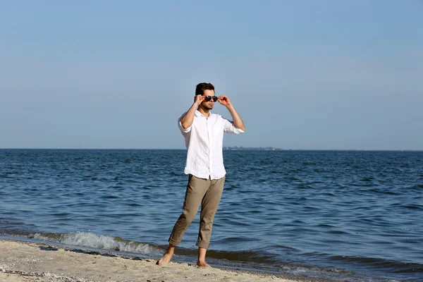 Junger Mann spaziert am Strand — Stockfoto