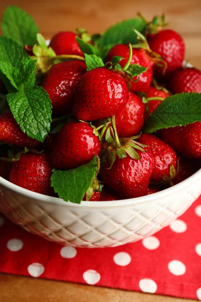 Rote reife Erdbeeren in Schale, auf farbigem Holzhintergrund — Stockfoto