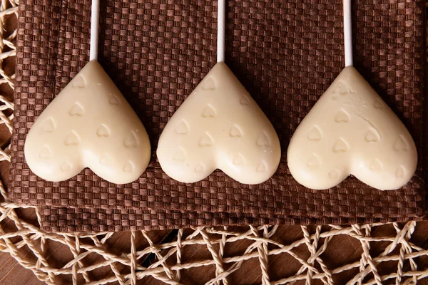 Schokolade herzförmige Bonbons auf Sticks auf brauner Serviette, Nahaufnahme — Stockfoto