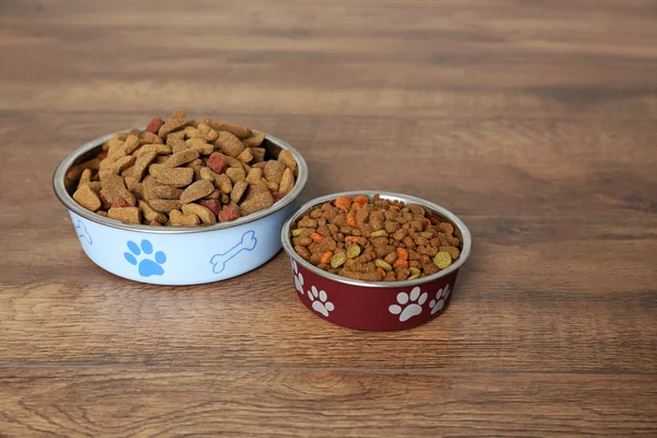 Comida para perros en tazones en el suelo en casa — Foto de Stock