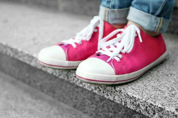 Pés femininos em gumshoes rosa em escadas de pedra — Fotografia de Stock