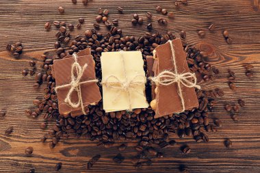 Stack of tied chocolate with coffee beans o wooden table, top view