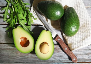 ahşap zemin üzerine dilimlenmiş avokado, roka
