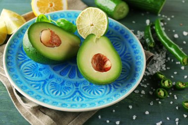 avokado ve limon kireç ahşap arka plan üzerine dilimlenmiş