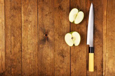 Ahşap arka plan üzerinde bıçak ile elma yarısı