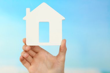 Turkuaz arka plan ev tutan el