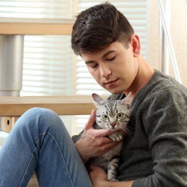 yakışıklı delikanlı ile evde basamaklarında oturan sevimli kedi