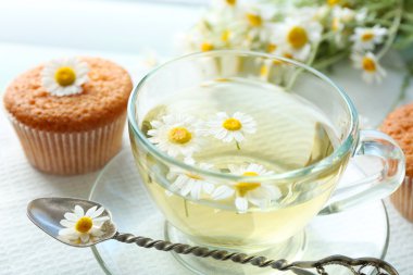 Papatya çay papatya çiçeği ve renk ahşap arka plan üzerinde lezzetli kekler ile