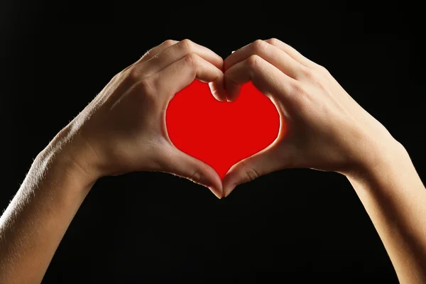 Human hands making heart on black background — Stock Photo, Image