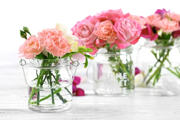 Schöne Frühlingsblumen in Glasflaschen — Stockfoto