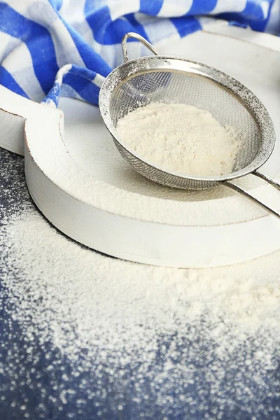 Sifting flour through sieve on wooden table, closeup — Stock Photo, Image