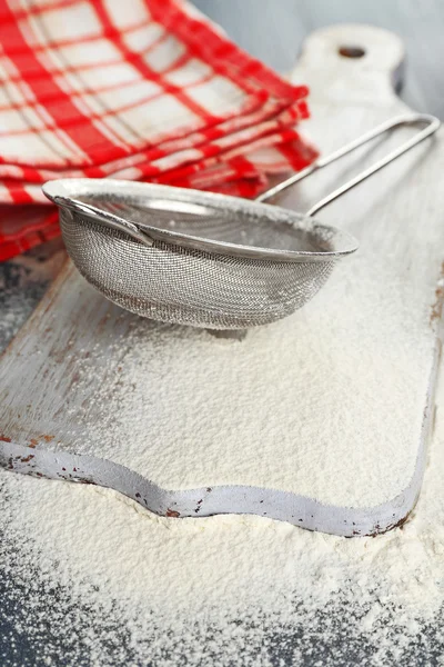 Sifting flour through sieve on wooden table, closeup — Stock Photo, Image