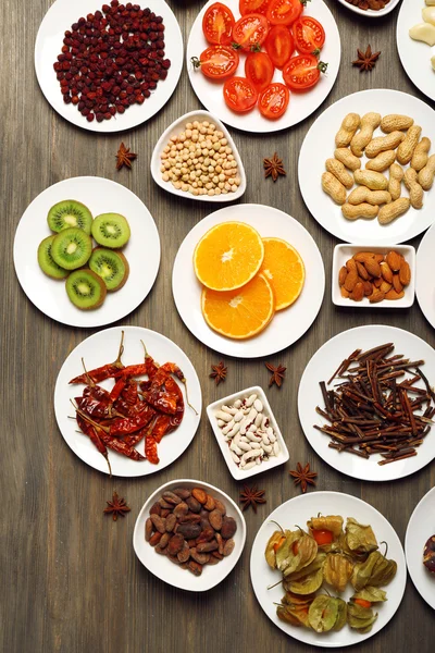Різні продукти на тарілках на дерев'яному столі, вид зверху — стокове фото