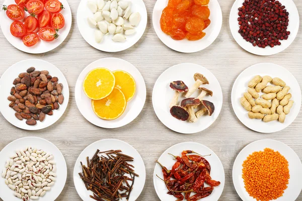 Different products on saucers on wooden table, top view — Stock Photo, Image