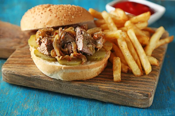 Hambúrguer saboroso e batatas fritas em fundo de mesa de madeira Conceito de comida insalubre — Fotografia de Stock