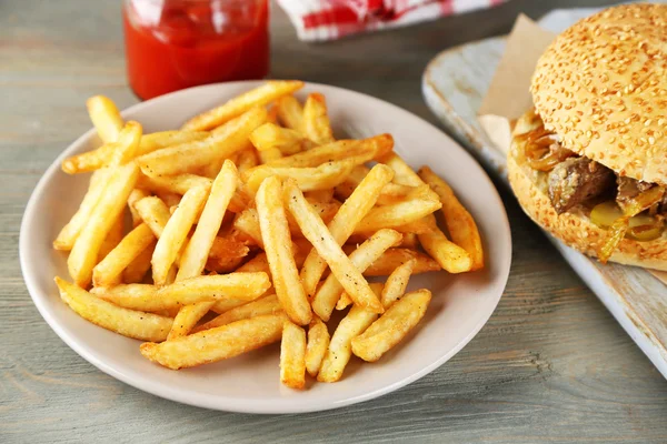 맛 있는 샌드위치 고 나무 배경에 접시에 감자 튀김. 건강에 해로운 음식 개념 — 스톡 사진