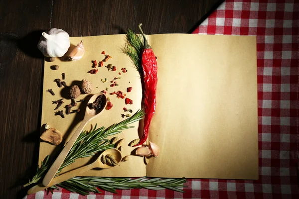 Libro de recetas abierto con hierbas frescas y especias sobre fondo de madera —  Fotos de Stock