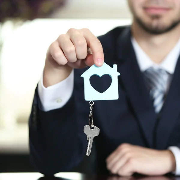 Retrato de homem de negócios com as chaves na mão no escritório em fundo borrado — Fotografia de Stock