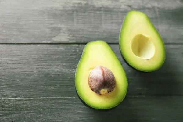 Aguacate en rodajas sobre fondo de madera —  Fotos de Stock