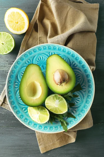 Avocado affettato e limone calce su sfondo di legno — Foto Stock