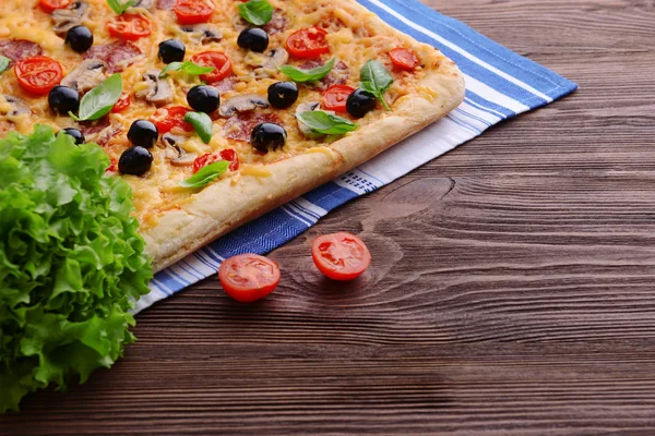 Leckere hausgemachte Pizza auf dem Tisch aus nächster Nähe — Stockfoto
