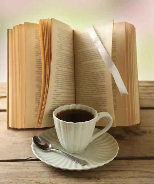 Cup of coffee and book on wooden table — Stock Photo, Image