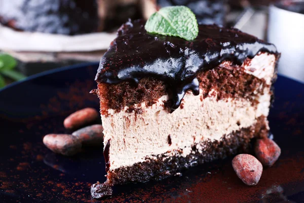 Delicious chocolate cake with icing in plate on table, closeup — Stock Photo, Image