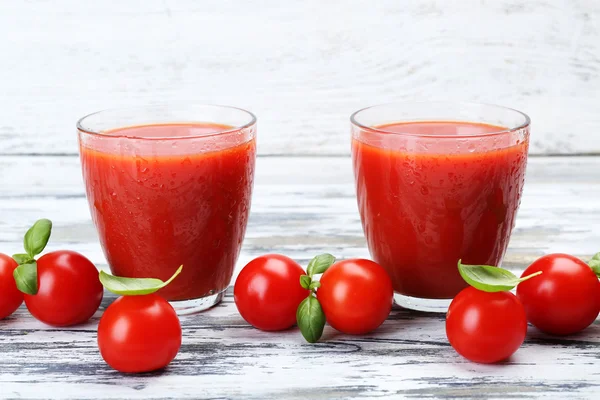 Copos de suco de tomate com legumes em fundo de madeira — Fotografia de Stock