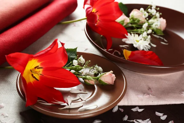 Посуда с цветами на столе крупным планом — стоковое фото