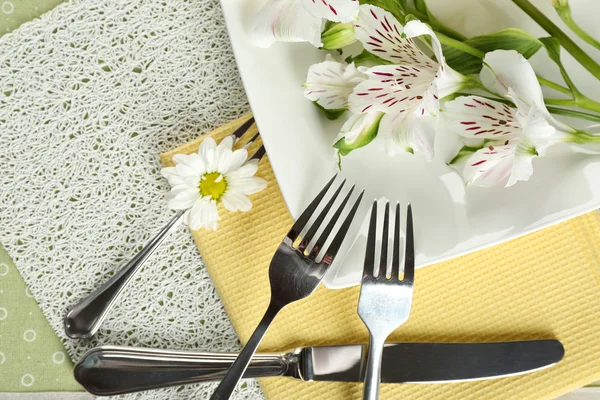 Посуда с цветами на столе крупным планом — стоковое фото