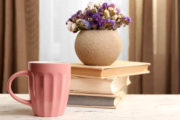 Boeken, cup en plant op houten tafel, close-up — Stockfoto