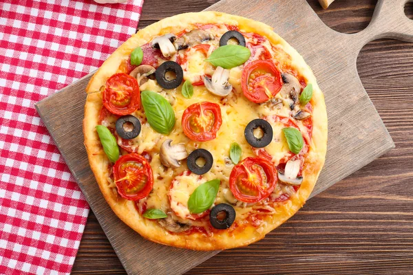 Dobrá pizza se zeleninou a bazalkou na stole zblízka — Stock fotografie