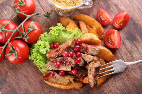 牛肉小红莓酱汁、 烤的土豆切片和面包上切菜板，木质的背景 — 图库照片