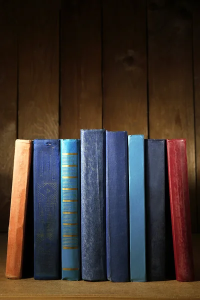 Oude boeken op plank, close-up, op donkere houten achtergrond — Stockfoto