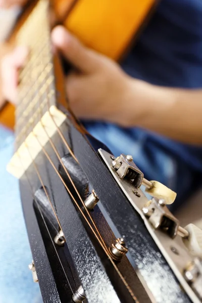 Young man playing on acoustic guitar close up — Stock Photo, Image