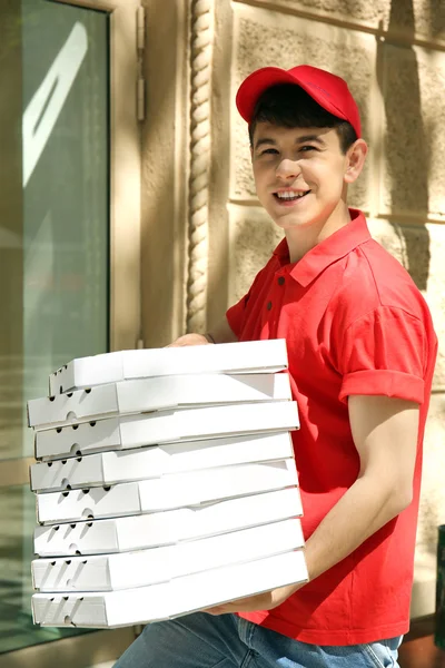 Jeune homme livrant une boîte à pizza près de la maison — Photo