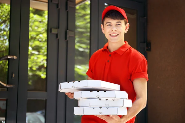 Ung man leverera pizza box nära house — Stockfoto