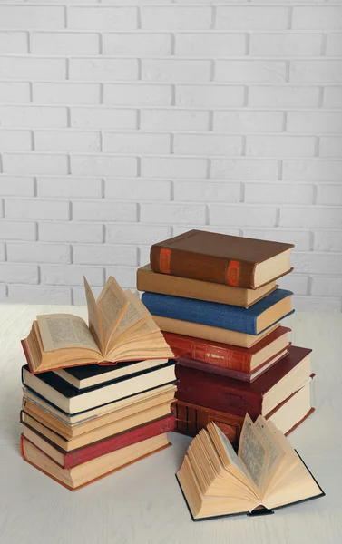 Heap of old books on brick wall background — Stock Photo, Image