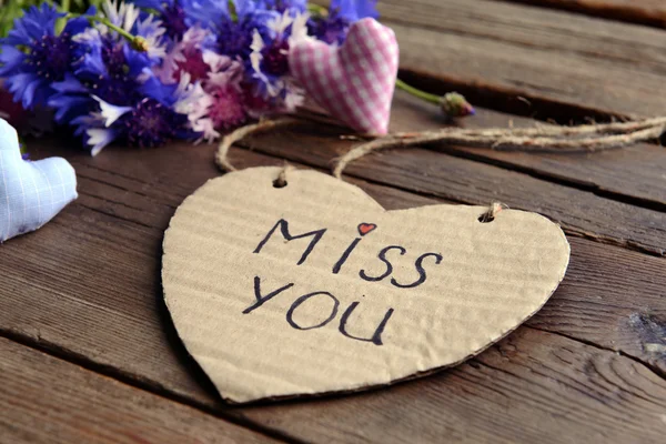 Schriftliche Botschaft mit trockenen Blumen und dekorativen Herzen auf Holztisch in Großaufnahme — Stockfoto