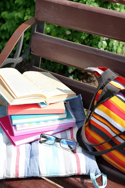 Books, glasses and bag on bench outdoors — Stock Photo, Image