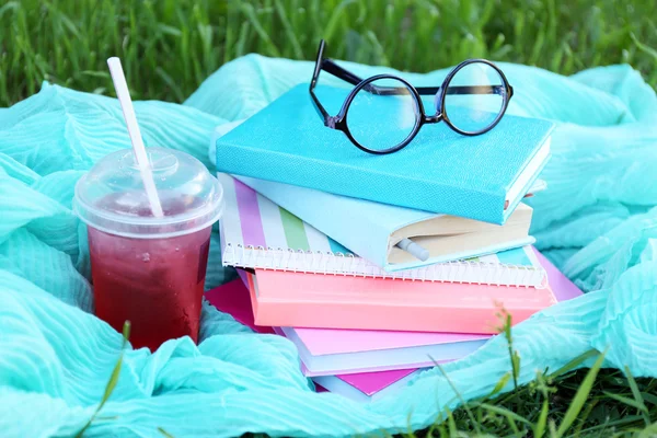 Könyvek, szemüveg és ital a fű közelről — Stock Fotó
