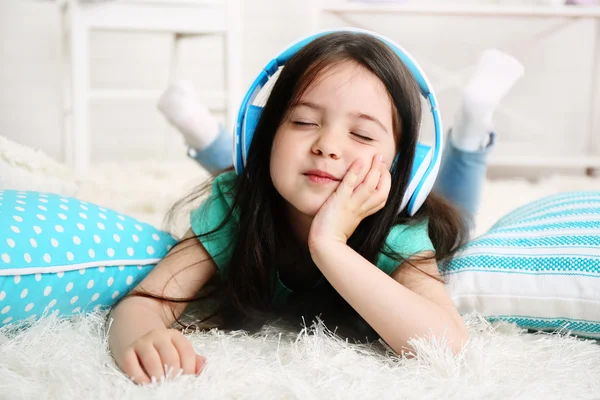 Vacker liten flicka lyssna på musik i rummet — Stockfoto