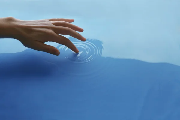 Prst dotýká vody zblízka — Stock fotografie