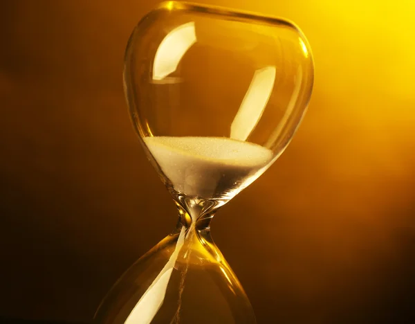 Hourglass on colour background — Stock Fotó